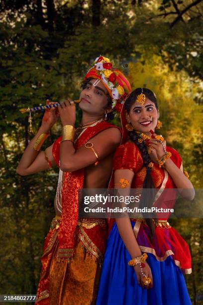 young man and woman dressed up as radha and krishna and romancing on the occasion of janmashtami - flute playing indian god stock pictures, royalty-free photos & images