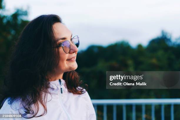 woman in glasses enjoying an outdoor moment - schoonheidsspecialist natuur stockfoto's en -beelden