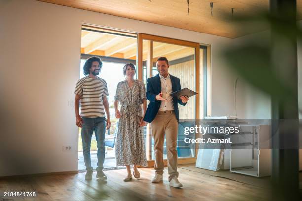 hispanic real estate agent guiding diverse clients in home viewing - real estate showing stock pictures, royalty-free photos & images