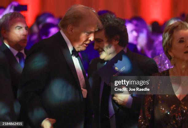 Argentine President Javier Milei walks past U.S. President-elect Donald Trump as they attend the America First Policy Institute Gala held at...