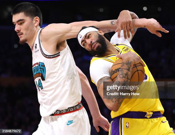 Anthony Davis of the Los Angeles Lakers reacts as he gets tangled with Zach Edey of the Memphis Grizzlies grabbing a rebound, during a 128-123 Lakers...