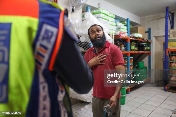 Members of SAPS inspect a spaza shop during a picket outside Jabulani UCB Offices where spaza shops owners were registering their businesses on...