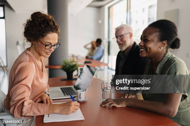 reunião de negócios com três profissionais sorridentes. - persuasão - fotografias e filmes do acervo