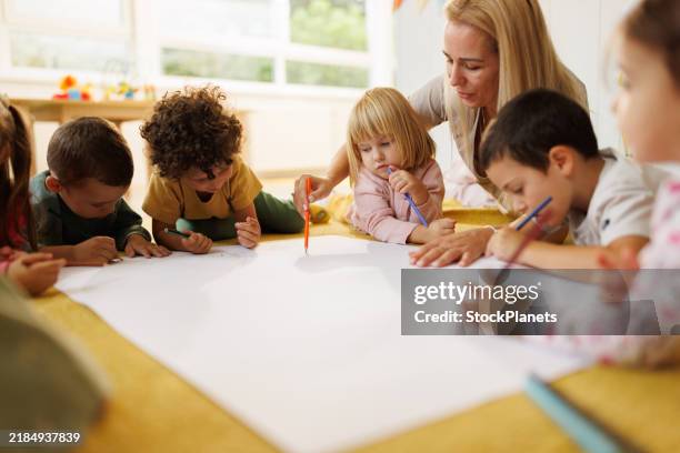kinder malen gemeinsam mit ihrer erzieherin - osteuropa stock-fotos und bilder