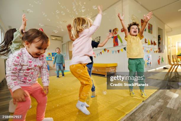 children having fun playing whit bubbles indoors - infantário imagens e fotografias de stock