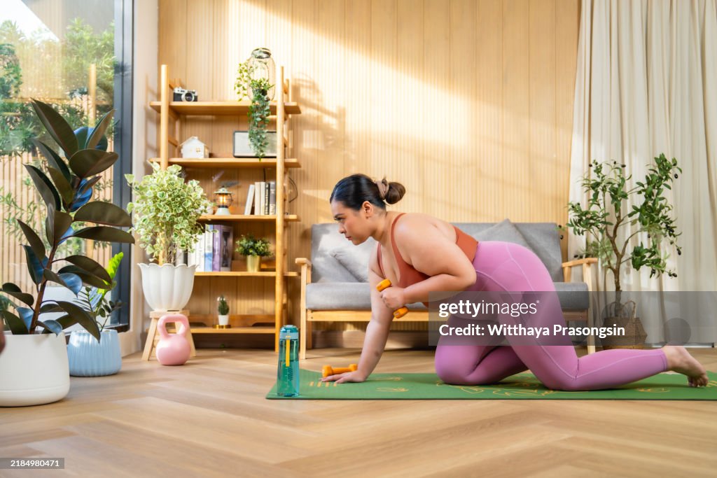 Woman Practicing Fitness with Dumbbells at Home in Bright Room