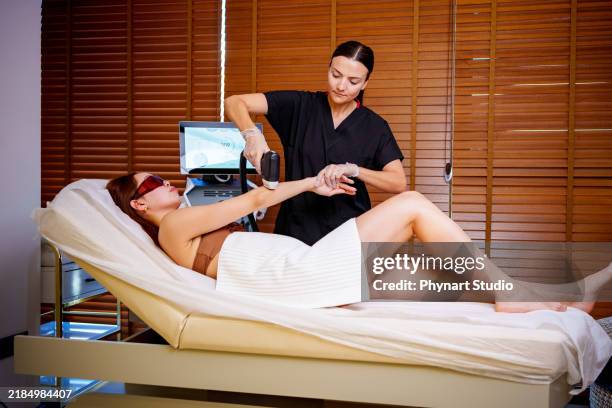 arm laser treatment in a spa setting - bare feet office stock pictures, royalty-free photos & images