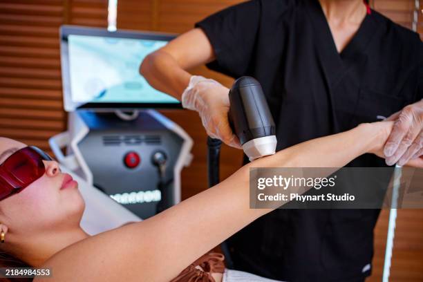arm laser treatment in a spa setting - bare feet office stock pictures, royalty-free photos & images