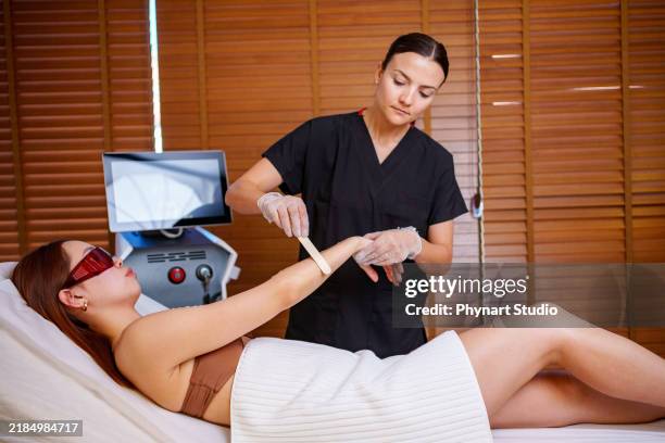 arm laser treatment in a spa setting - bare feet office stock pictures, royalty-free photos & images