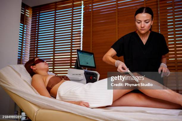 leg laser treatment in a spa setting - bare feet office stock pictures, royalty-free photos & images