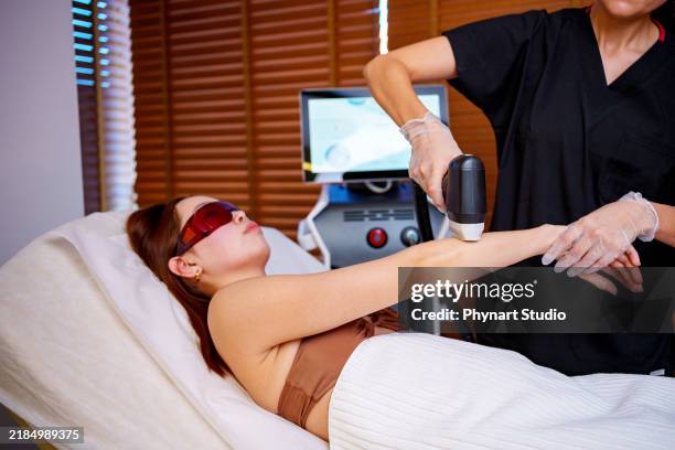 arm laser treatment in a spa setting - bare feet office stock pictures, royalty-free photos & images