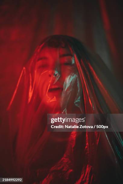 woman in plastic wrap in red and green light - suffocated stock pictures, royalty-free photos & images