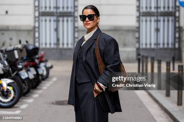 Gili Biegun wears Herskind beige thinstripe shirt and Herskind thinstripe balloon trousers with matching vest and oversized blazer, Celine...