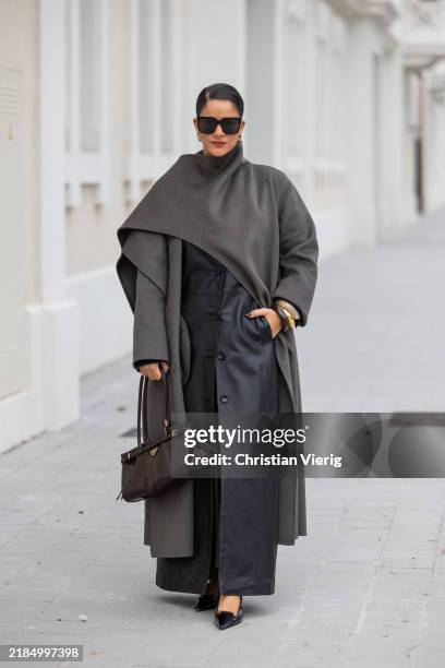 Gili Biegun wears brown leather Prada bag, Celine sunglasses, Saint Laurent black slingback kitten heels, Envelope 1976 black maxi skirt, grey Zara...