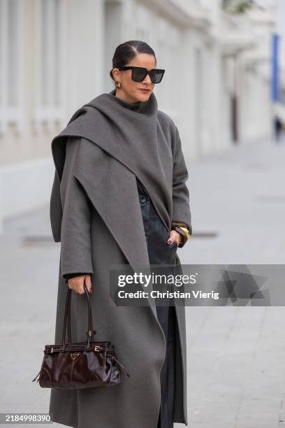 Gili Biegun wears brown leather Prada bag, Celine sunglasses, Envelope 1976 black maxi skirt, grey Zara wool scarf coat, black Manokhi leather...