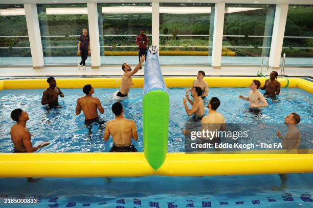 Players of England play a game of volleyball in the swimming pool as part of a recovery session at St George's Park on November 15, 2024 in Burton...