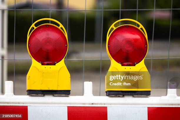 two red warning lights at a construction site on the street - barrikade stock-fotos und bilder