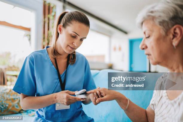 profesional de la salud de atención domiciliaria que usa oxímetro - visita a domicilio fotografías e imágenes de stock