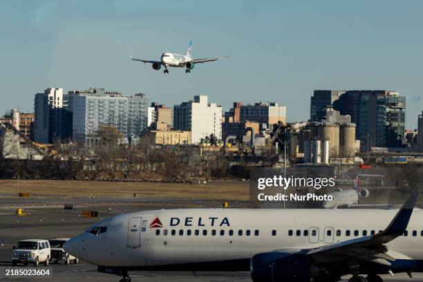 Frontier Airlines Airbus A320neo passenger aircraft spotted on final approach flying for landing in LaGuardia Airport over Delta Air Lines Boeing 737...