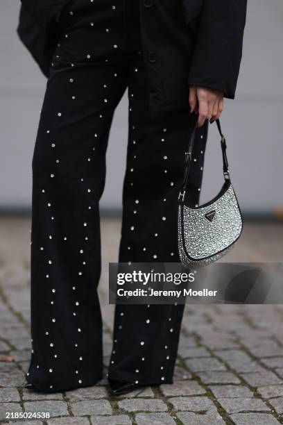 Sonia Lyson is seen wearing a padded black jacket from Marina Hoermanseder x About You; wide-legged straight black jeans with rhinestones pattern...