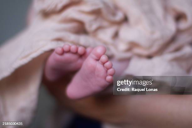 newborn baby feet extending from swaddle blanket - manta de bebé imagens e fotografias de stock