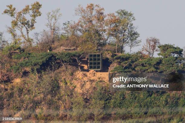 In this photo taken on November 7 a North Korean loudspeaker is seen beyond a fence from South Korea's border island of Ganghwa, where residents are...