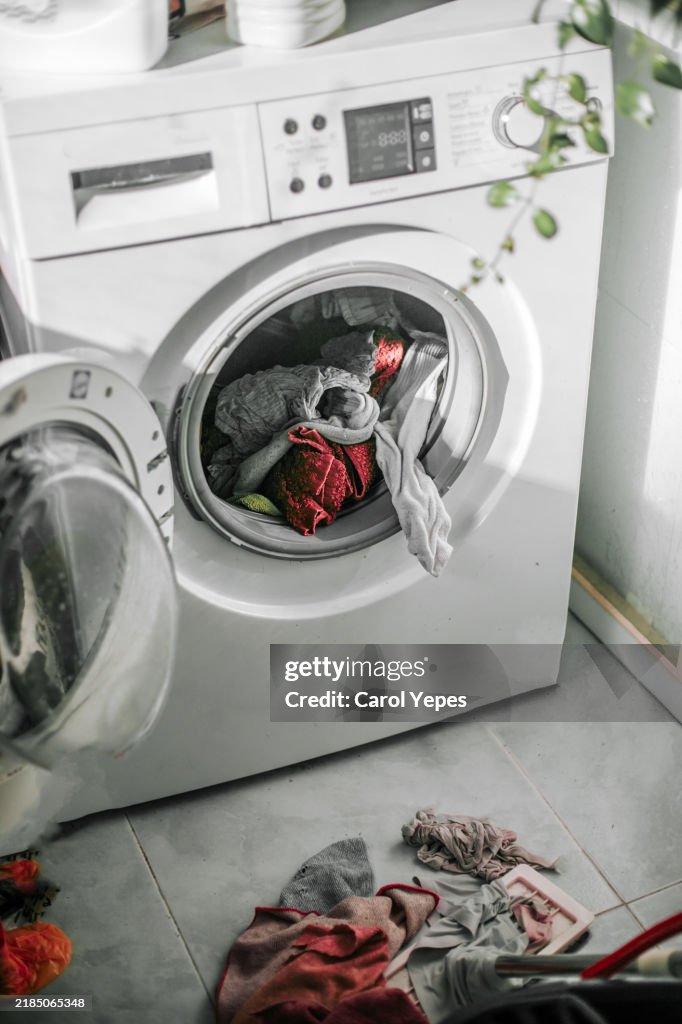 Simple image of a modern washing machine and a washing basket filled with freshly laundered towels