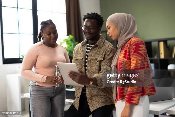 une équipe de bureau multiculturelle partageant des idées pour un projet - voile religieux photos et images de collection
