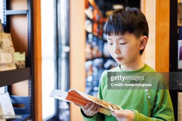 little china boy is reading in a bookstore - book shop stock pictures, royalty-free photos & images