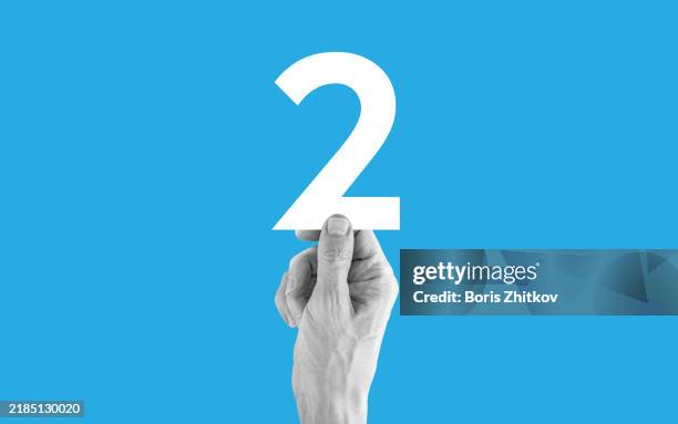 hand holding number 2 - ziffer 2 stock-fotos und bilder