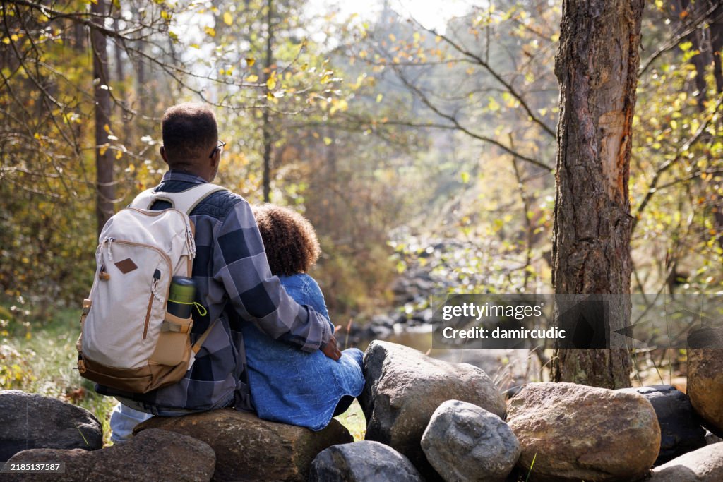 Single father spending some time in forest with his daughter, enjoying nature