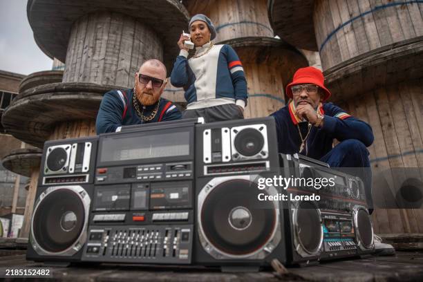 a lifestyle group of three adults with boom boxes representing analog revival and 1980s hip hop culture - hi fi stock pictures, royalty-free photos & images