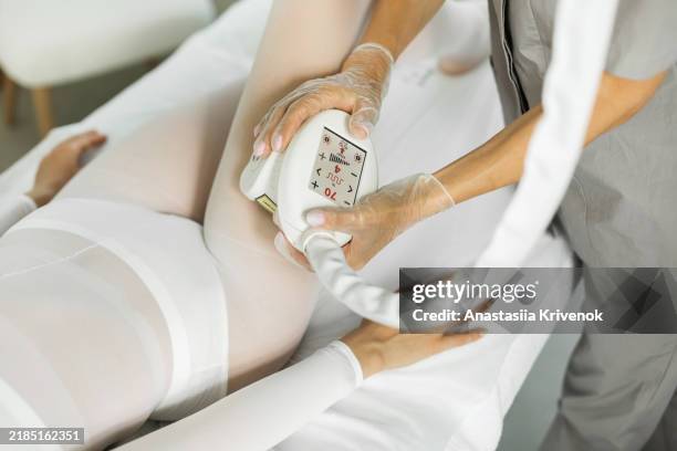 close up of doctor hands massaging area of hip for beautiful slim woman in lpg suit in medical clinic. - liquefied petroleum gas stock pictures, royalty-free photos & images