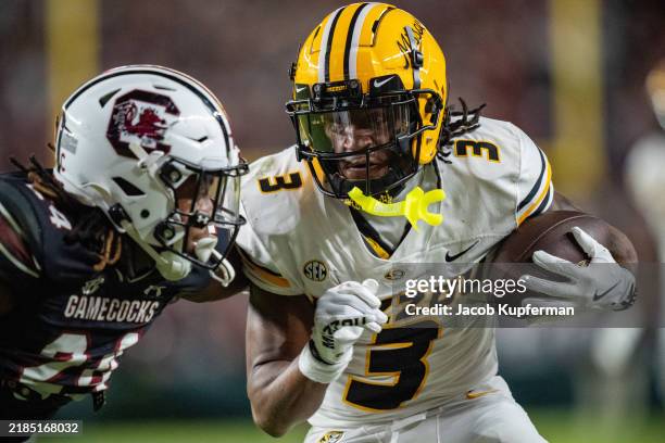 Luther Burden III of the Missouri Tigers makes a catch for a touchdown while covered by Jalon Kilgore of the South Carolina Gamecocks in the fourth...
