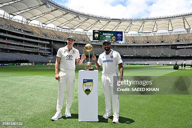 Australia's captain Pat Cummins and India's captain Jasprit Bumrah pose with the trophy at Optus Stadium in Perth on November 21 ahead of the first...