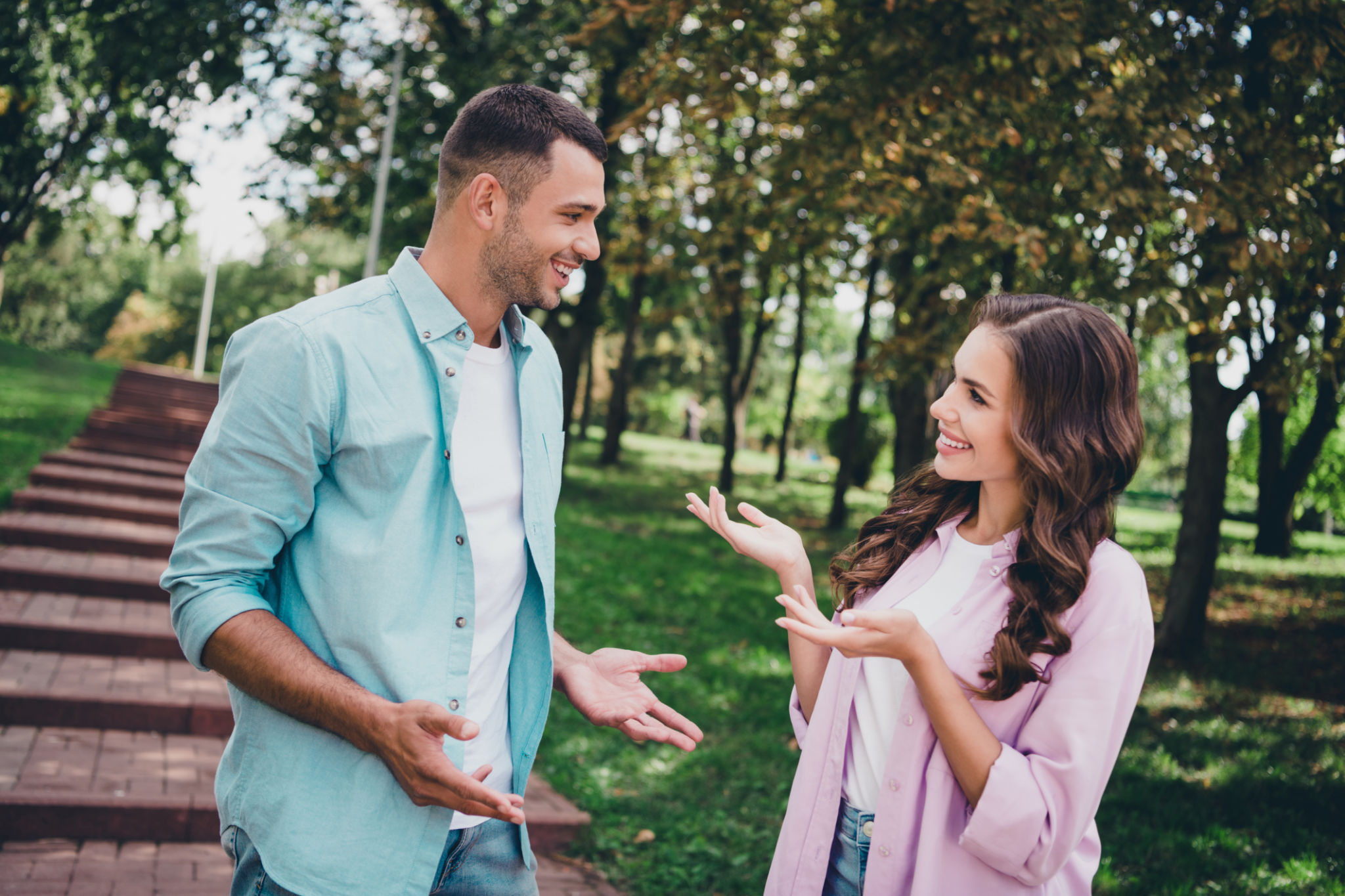 Portrait of two friendly positive people communicate say tell spend free time walking outside Portrait of two friendly positive people communicate say tell spend free time walking outside