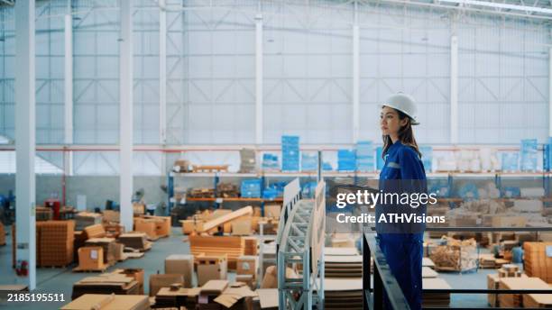 ingegnere donna che supervisiona le operazioni di magazzino con l'equipaggiamento di sicurezza - occupazione industriale foto e immagini stock