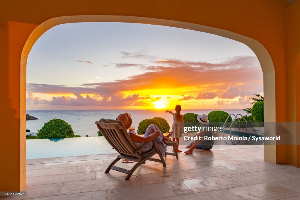Happy family watching sunset in a luxury villa