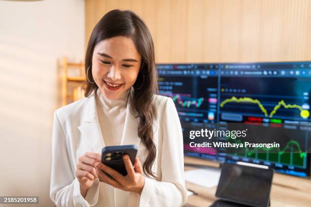 confident woman trader analyzing cryptocurrency data on smartphone - digital currency stock pictures, royalty-free photos & images