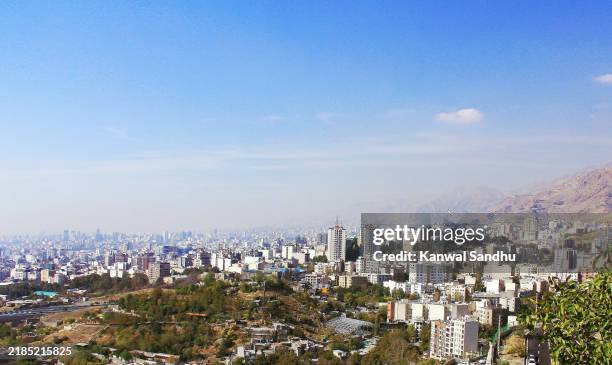 panoramic view of tehran metropolis from darband valley on a clear blue sky day with the alborz mountains on the right. - tehran stock pictures, royalty-free photos & images