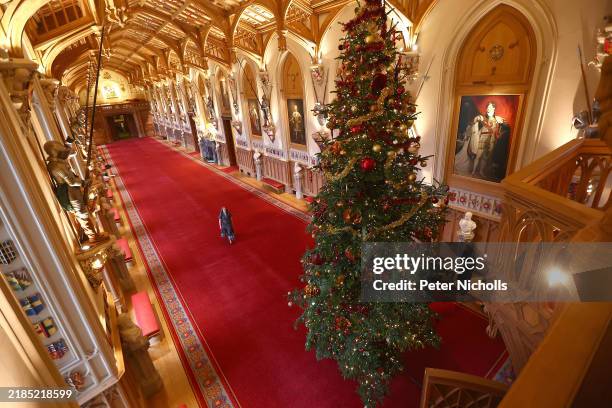 Royal household staff pose for a photograph next to a decorated Christmas tree at Windsor Castle on November 21, 2024 in Windsor, England. During...