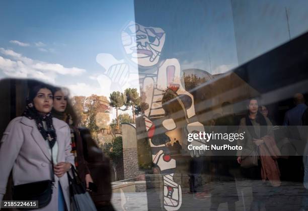 Iranian women walk past ''Cherche Aubaine'' from the series ''Deputation'' by Jean Dubuffet, the French painter and sculptor, while visiting the...