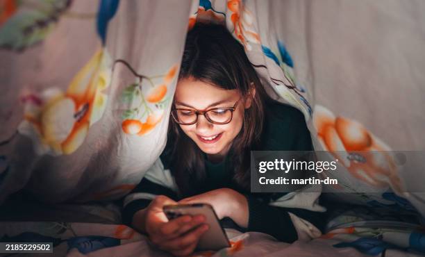 girl using smart phone under blanket - generation alpha stock pictures, royalty-free photos & images
