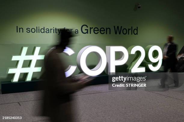 Attendees walk past the COP29 logo during the United Nations Climate Change Conference in Baku, Azerbaijan, on November 21, 2024.