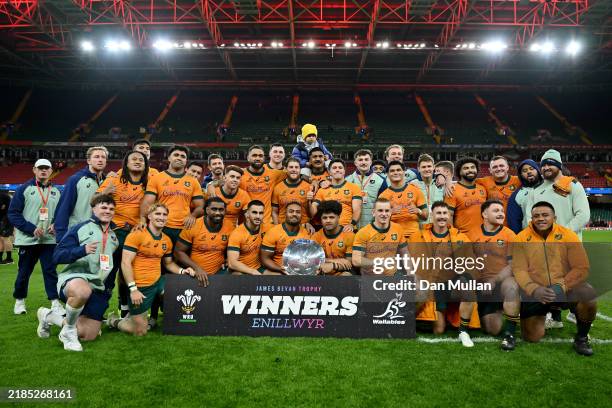 Players of Australia pose for a photo with coaching staff as they celebrate victory with the James Bevan Trophy after defeating Wales during the...