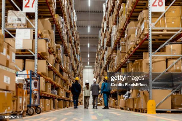 warehouse owners and team walking through inventory area for review - distribution warehouse stock pictures, royalty-free photos & images