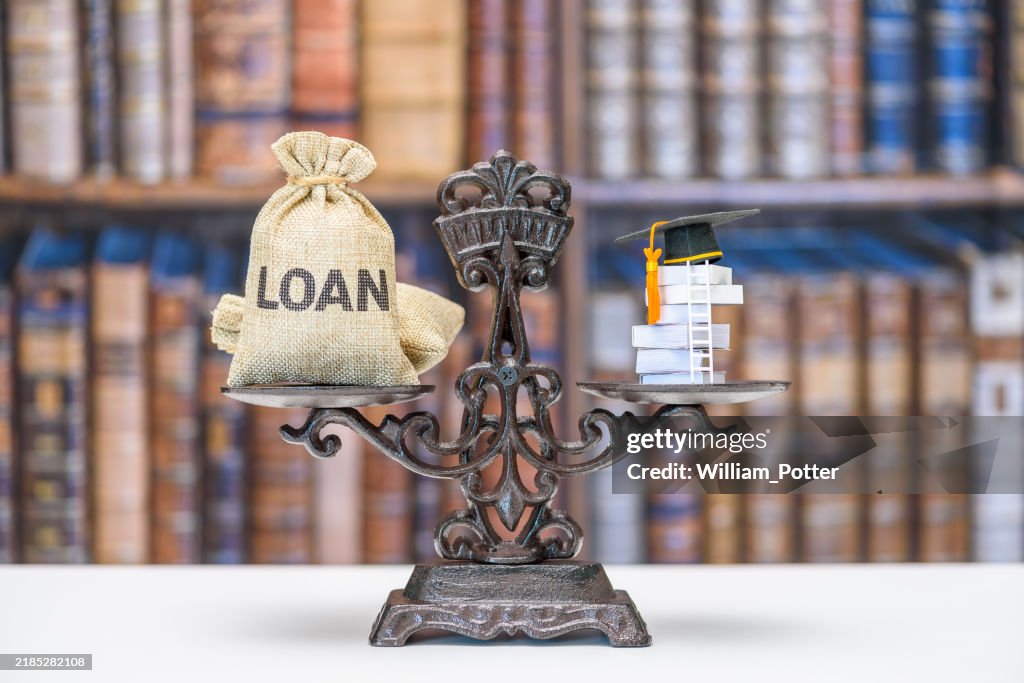 Student loan, education costs, financial burden related to higher education : A balance scale with a sack labeled "LOAN" on one side and a stack of books topped with a graduation cap on the other.
