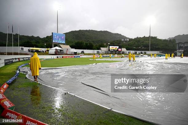 Groundstaff bring on the covers as rain stops play during the 5th T20 International between the West Indies and England at Daren Sammy National...