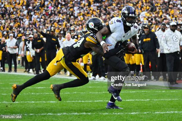 Joey Porter Jr. #24 of the Pittsburgh Steelers tackles Lamar Jackson of the Baltimore Ravens short of the end zone to stop two point conversion...