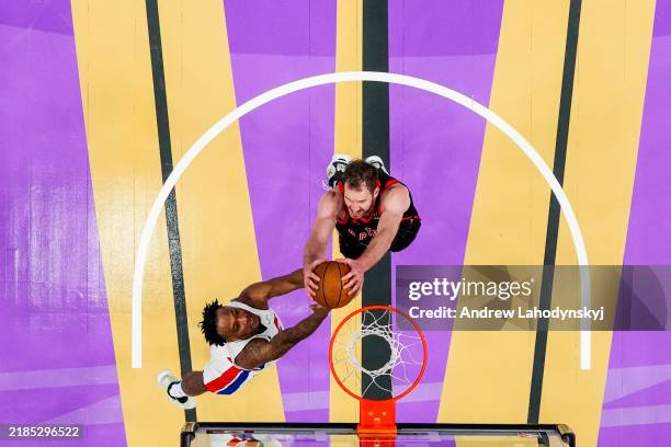 Ronald Holland II of the Detroit Pistons and Jakob Poeltl of the Toronto Raptors battle for the rebound during the Emirates NBA Cup game at...